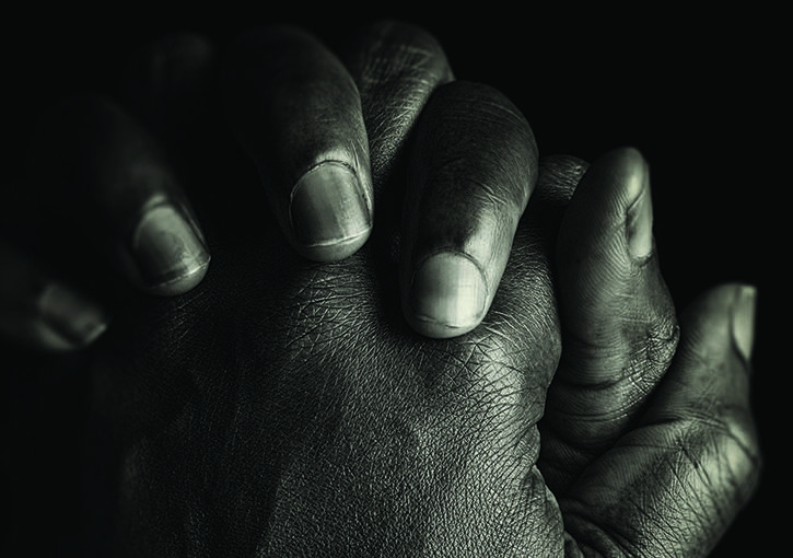 Hands of one individual, clasped together in prayer.