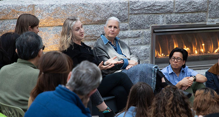 people gather around a fire and talk