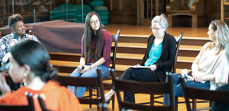 four people sit and discuss