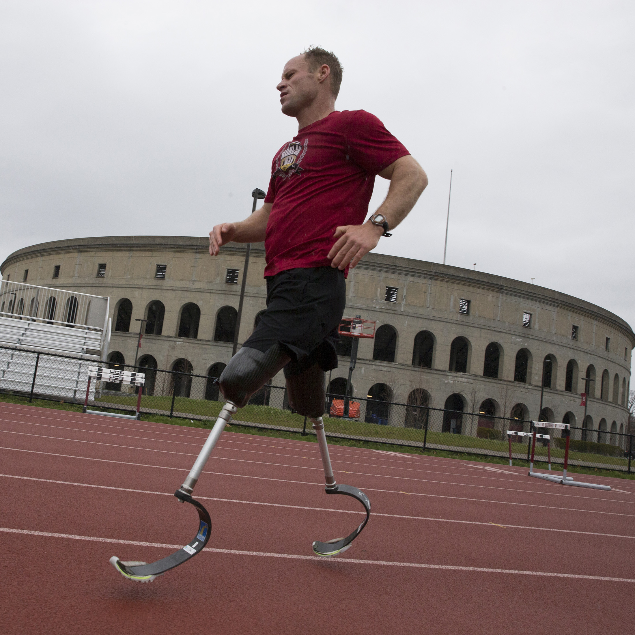 Dan Cnossen training on a track with Memorial Stadium in the background