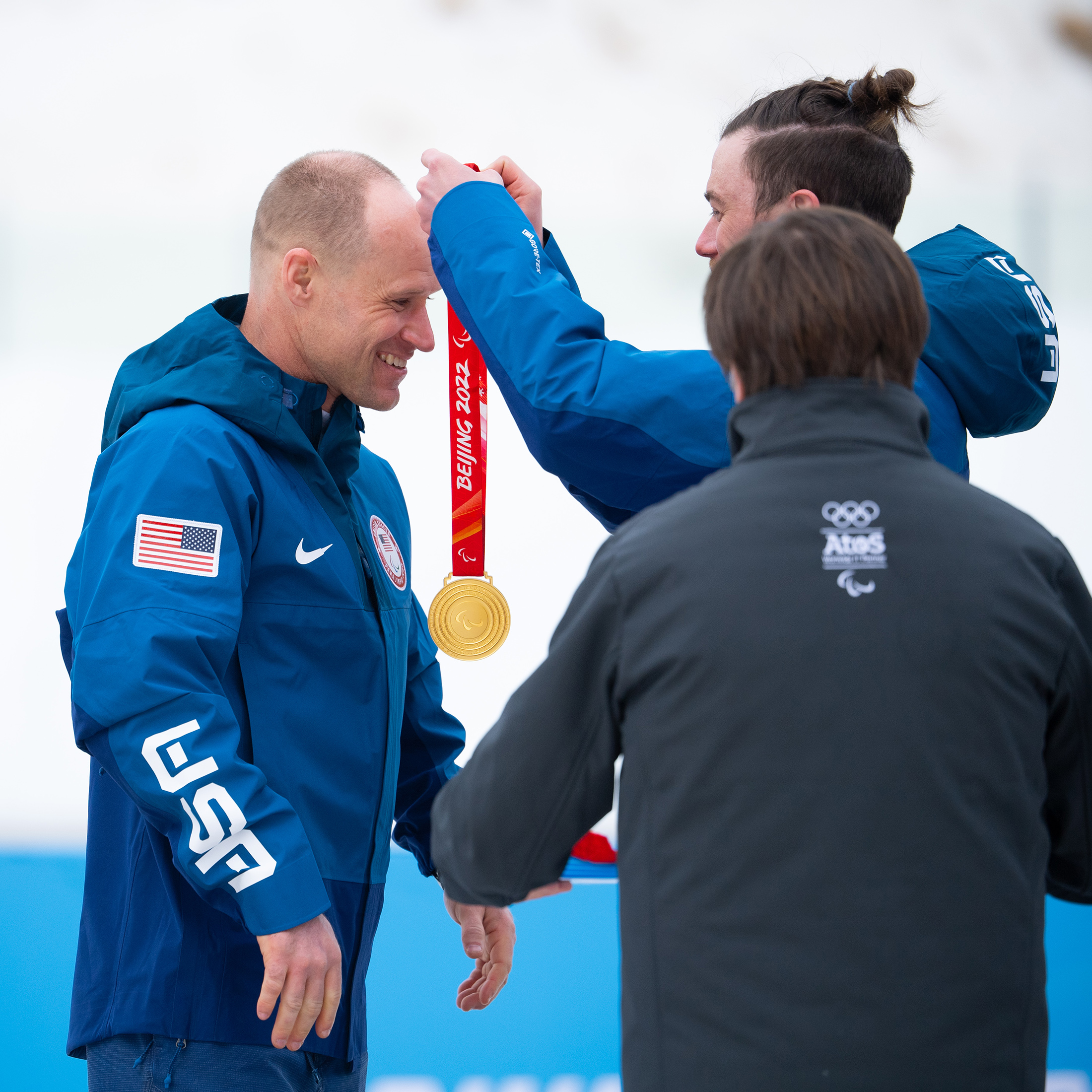 Dan Cnossen having the gold medal placed around his neck