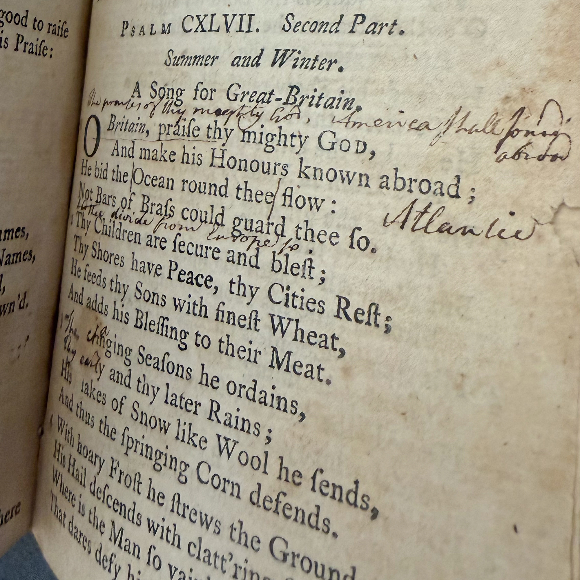A historic book of hymns by Isaac Watts with scribbled out lyrics replaced by hand-written words in the margins of the page