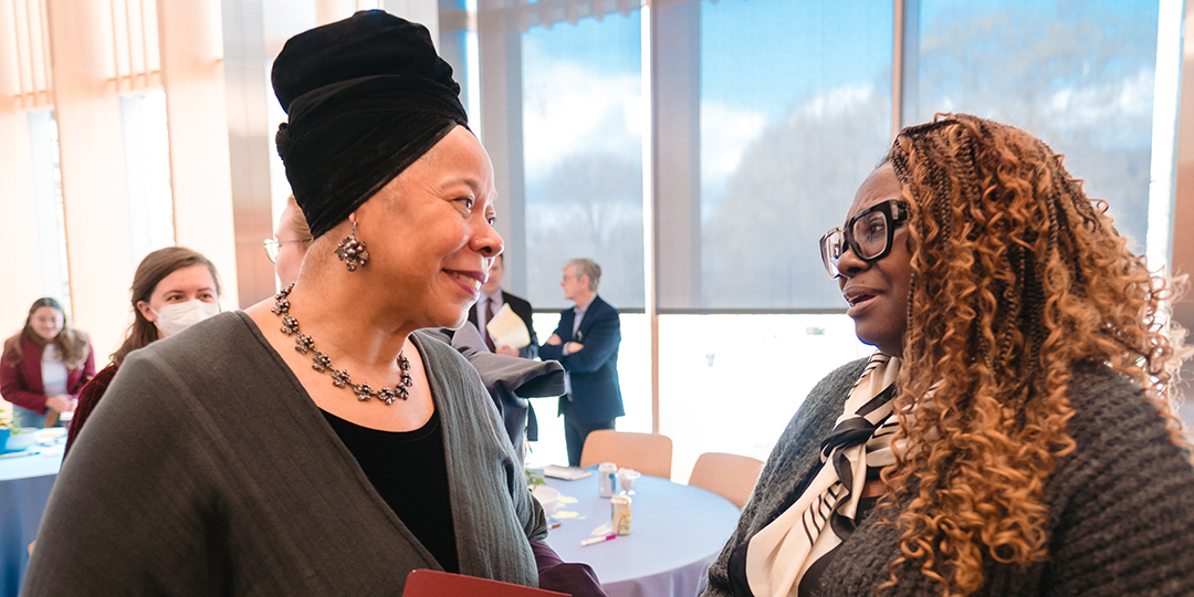 Prof. Tracey Hucks and Bernadette Edmonds-Holder talk near a set of tables