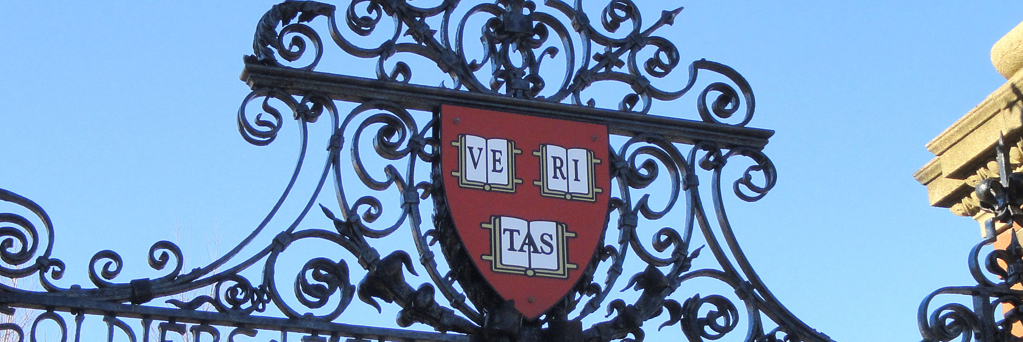 Harvard shield on top of a decorative gate