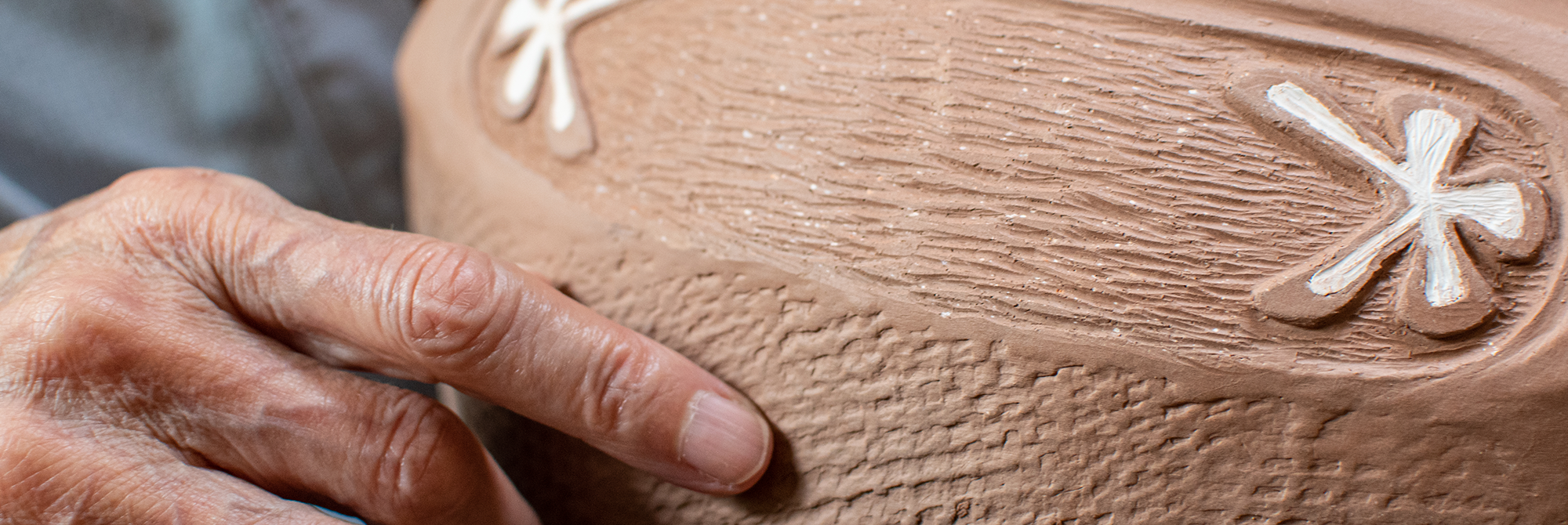 Ramona Peters points to the detailing of her work, "Earth Bound" now on display in Swartz Hall