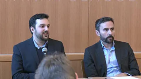 two panel participants discuss during an event 