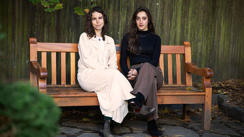 Paula Ortiz and Lia Pikus sitting on a bench in the CSWR courtyard. Photo: Alex Bayer