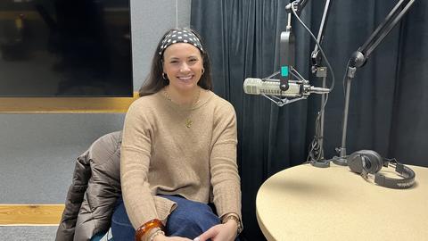 Julia Jackson sits at a table with a microphone next to her