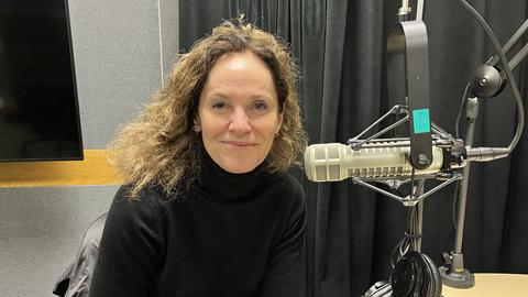 Amy Brenneman headshot with podcast microphone to her left