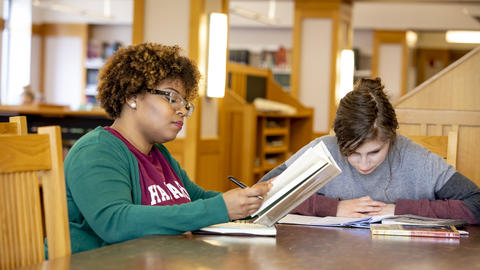Two HDS students study in the library