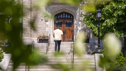 Man walking up the steps of Swartz Hall toward the entrance