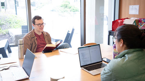 Two HDS students working on laptops
