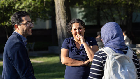 HDS professor and two students talking out on the campus green