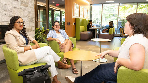 Three students hanging out in the HDS Commons