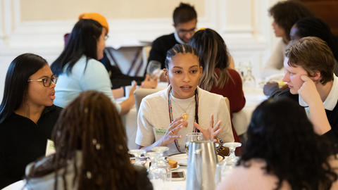 DivEx students sit around a table and discuss