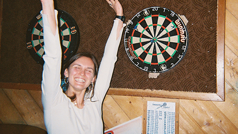 Maya Pace smiling, with arms stretched upwards