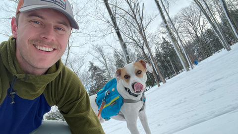 Owen and his dog, in a snowy landscape, looking at the camera