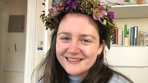 Phoebe in a flower crown smiling at the camera