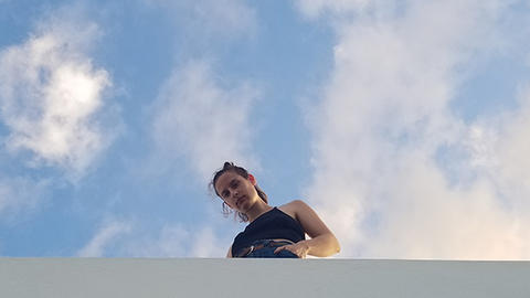 HDS student Allison Rosen standing on a roof with blue sky behind her in Puerto Rico