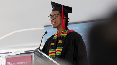 jessica young chang in academic regalia speaking at a podium at Harvard Divinity School's diploma awarding ceremony