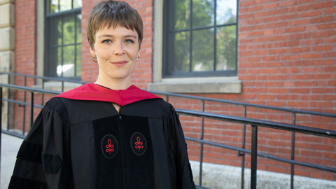 Maggie Rogers wearing black graduation regalia in Harvard Yard