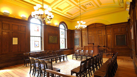 Sunlit chapel, with dark wooden walls, chairs set up in the center