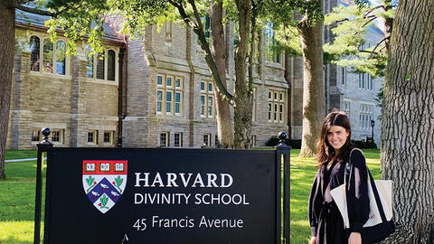 Ellie Green standing by Harvard Divinity School campus sign
