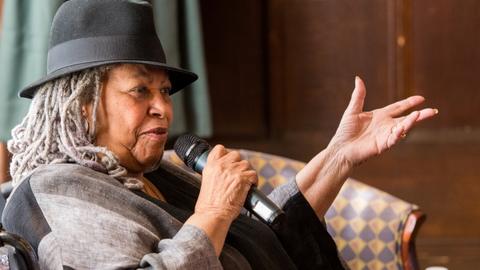 Toni Morrison seated speaking into microphone