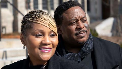 Joi and Raymond Carr looking to the right in front of Swartz Hall at Harvard Divinity School