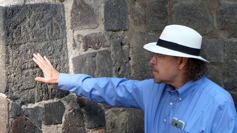 Professor David Carrasco touching a stone wall