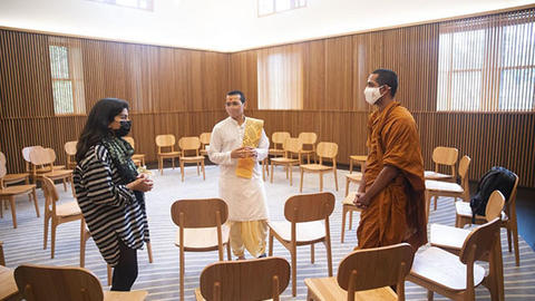 Three HDS students talking with each other in a spacious room