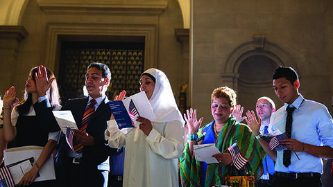 Petitioners are sworn in as new citizens during a naturalization ceremony at the National Archives in 2014.