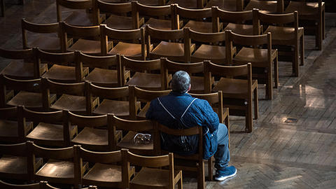 A man sits alone in a church sanctuary during the early days of the Coronavirus outbreak. / Photo: Catholic Church of England and Wales