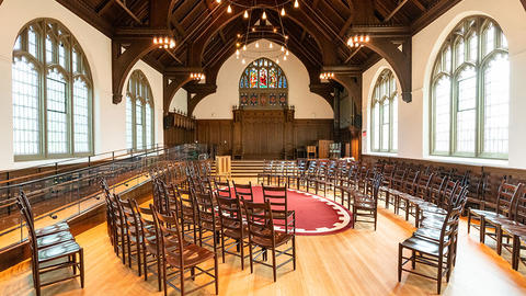 Christian chapel with large glass windows and chairs set up in an oval