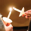 Photo of HDS students passing the flame from one candle to another