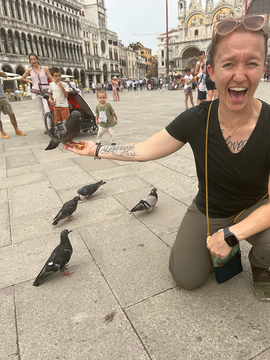 Amy Sexauer on a street in Europe feeding pigeons