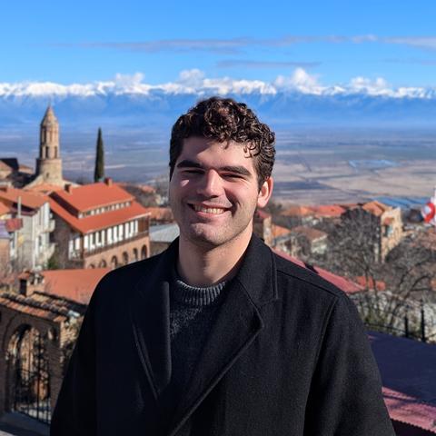 Headshot of Alexander John Paul Lutz in front of a European city