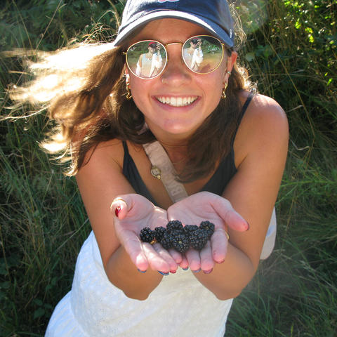 Julia Jackson holding blackberries with green background