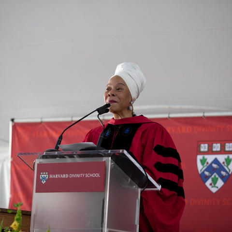 Tracey Hucks delivers an address behind a podium at Commencement