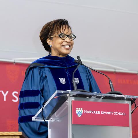 Dean Frederick speaks behind podium at Commencement