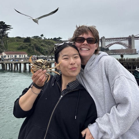 Audrey Zhou and Paige Scanlon pose by the water during their summer field ed placement