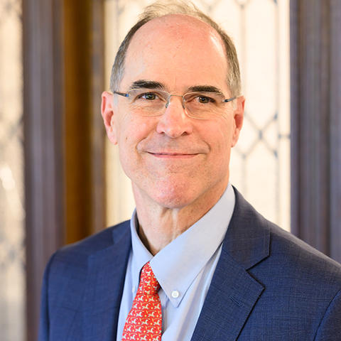 David Lamberth in glasses and a suit looking at the camera