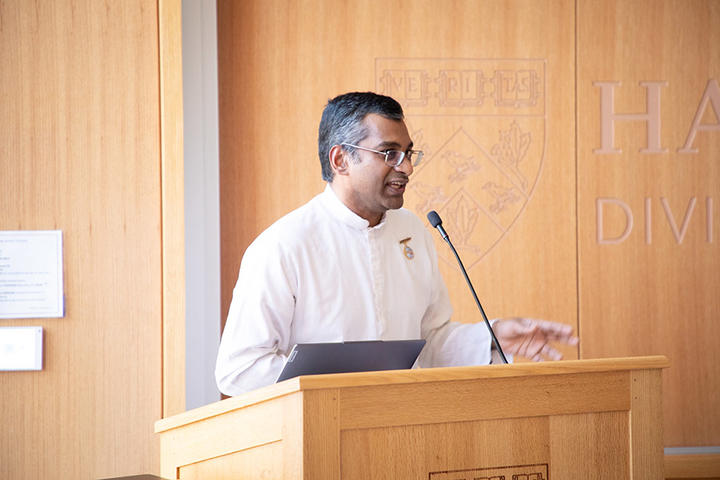 Sundar standing behind lectern with brown background to the right