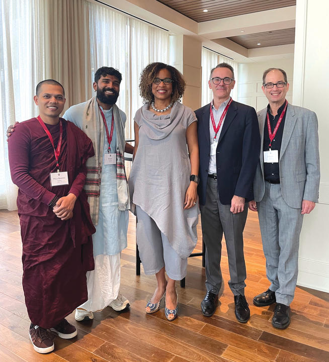 Dean Frederick with friends in a room with windows behind