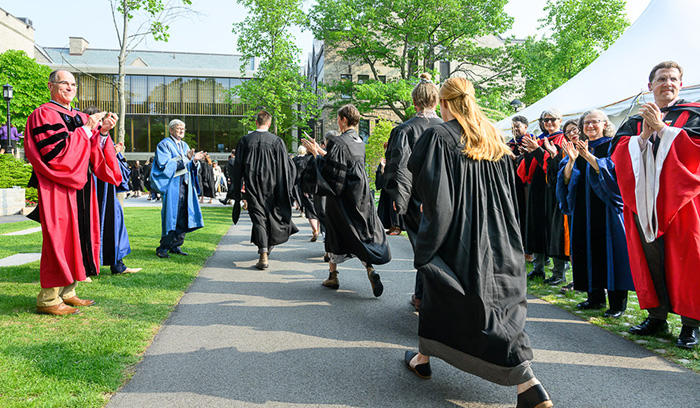 HDS faculty line up and applaud new HDS graduates.