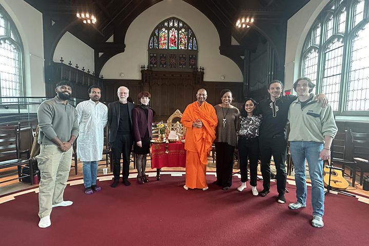 People stand together after an event, smiling and looking into the camera
