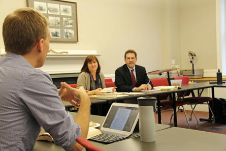 Professors Catherine Brekus and David Holland look at a student in a classroom at HDS