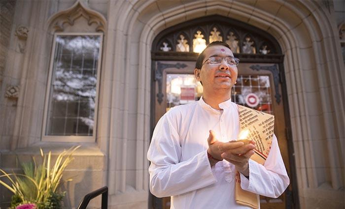 Sadhak Vandan, a Hindu monastic and Divinity School student, celebrates Diwali at dusk outside Swartz Hall.