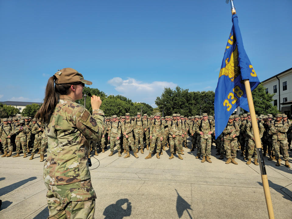 Jenna Carson giving a pep talk in military uniform to group of military personnel