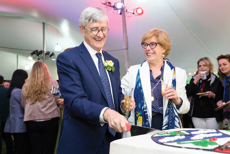 Dean Hempton cuttinga cake while Louanne Hempton grins at him